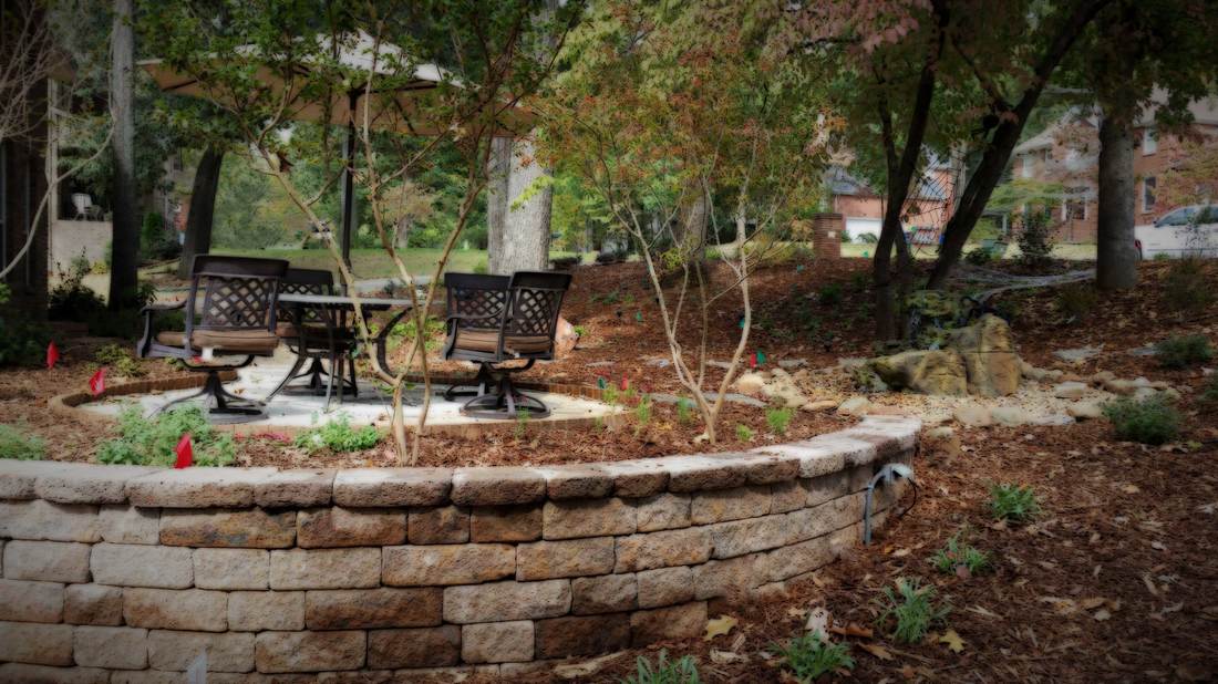 Photo of new landscape install with retaining wall, patio and water fountain.  Woodland garden with native perennials.  A Green Thumb Design project in Madison, Alabama.